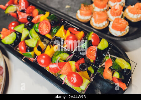 Different types of canapes on buffet table Stock Photo