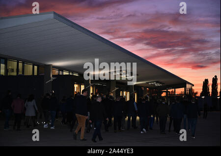 11 October 2019, Saarland, Saarbrücken: Members of the young Union go to the congress hall at the Germany Day of the Young Union, while the evening sky is reddish. Photo: Harald Tittel/dpa Stock Photo