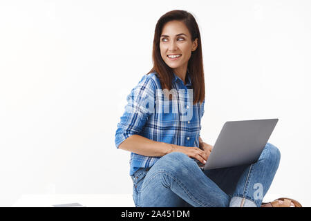 Good-looking ambitious female entrepreneur computer programmer writing code, sitting comfortable pose crossed legs floor, turn left copyspace smiling, Stock Photo