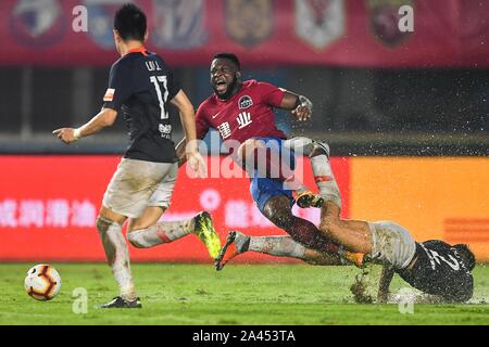 Cameroonian football player Franck Ohandza, center, of Henan Jianye passes the ball against players of Beijing Renhe in their 23rd round match during Stock Photo