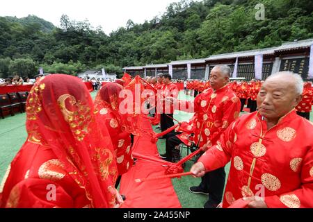 Chinese elderly couples take part in a group wedding ceremony to celebrate traditional Chinese festival Qixi Festival, also known as the Chinese Valen Stock Photo