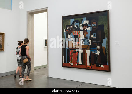 Philadelphia Museum, view of two young women walking past Three Musicians by Pablo Picasso in the Philadelphia Museum Of Art, Pennsylvania, PA, USA Stock Photo