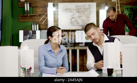 Two young architects working on urban plan for office buildings. Creative architects. Stock Photo