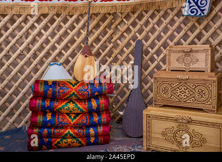 Wooden dowry chest near some asian carpets and some other traditional things. Stock Photo