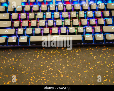 RGB keyboard. A colorful keyboard shimmers with different colors. lying on the table. Soft bokeh Stock Photo