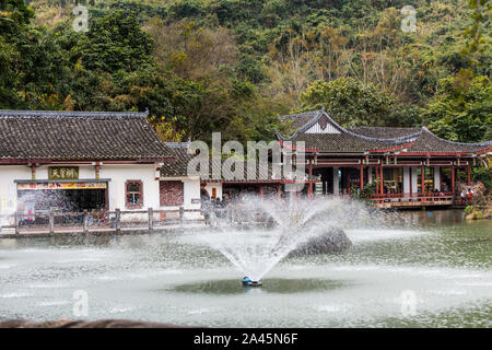 Gift shops in the Chinese ancient house with The Tianxing lake and fountain, in the National park of Huangguoshu waterfall, in Guizhou province of Chi Stock Photo