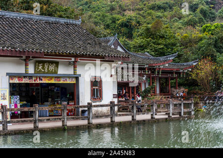 Gift shops in the Chinese ancient house with The Tianxing lake and fountain, in the National park of Huangguoshu waterfall, in Guizhou province of Chi Stock Photo