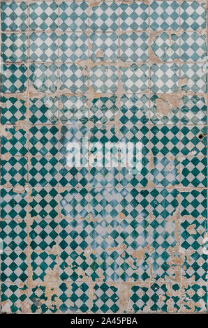 Close-up of an old, weathered and cracked wall with colorful ceramic tiles (azulejos) in Lisbon, Portugal. High resolution full frame background. Stock Photo