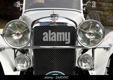 Front grill and headlights of a white mid 1930s Alvis Speed 20 classic car at Goathland railway station North Yorkshire England Stock Photo