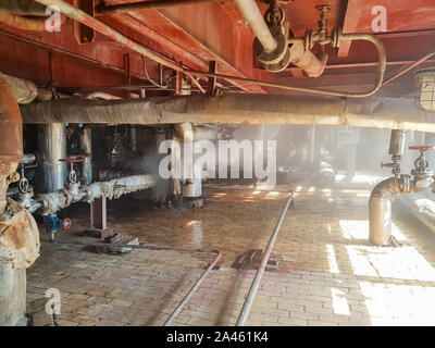 steam from the pipe. under pressure in production. factory breakdown. gas leak. Leakage of steam in heat pipeline interior industrial gas with a lot Stock Photo