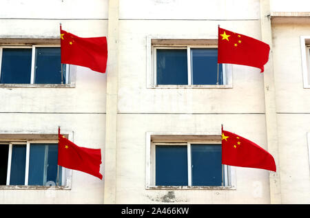 Chinese national flags flutter on the windows at the campus of Liaoning University Of Traditional Chinese Medicine to mark the upcoming National Day i Stock Photo