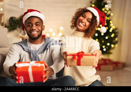 Happy New Year! Afro couple stretching gift boxes Stock Photo