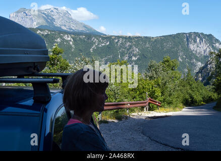 Woman near car (unrecognizable) on secondary countryside road through mountain Durmitor National Park, Montenegro, Europe, Balkans Dinaric Alps, UNESC Stock Photo