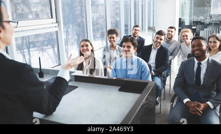 Young business team listening to speaker at meeting Stock Photo