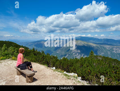 Woman on wooden bench over picturesque summer Tara Canyon in mountain Durmitor National Park, Montenegro, Europe, Balkans Dinaric Alps, UNESCO World H Stock Photo