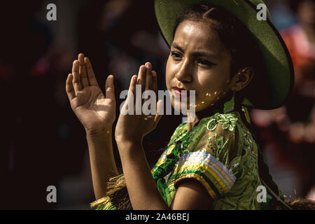 Barcelona, Spain. 12 October, 2019:  A young Bolivian girl in her traditional costume dances as she parades through Barcelona to celebrate the Columbus Day Credit: Matthias Oesterle/Alamy Live News Stock Photo