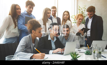 Business professionals analyzing data on laptop in office Stock Photo