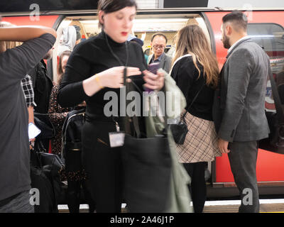 Evening rush hour on the London underground tube network, passengers disembark train Stock Photo