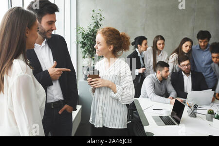 Happy business colleagues communicating in office during break Stock Photo