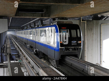 A line 3 monorail train leaves Tongyuanju on a bridge with roadway above across the Yangtse river in Chongqing city, China. Stock Photo