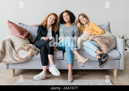 Happy restful girls in casualwear relaxing on couch at home Stock Photo