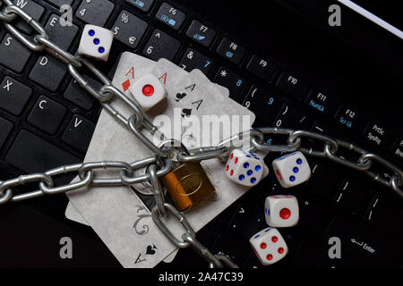 Bekasi, West Java, Indonesia October 13 2019 : Padlock and playing cards. Isolated on laptop keyboard. Onlie gambling concept Stock Photo