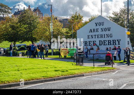 DERRY, LONDONDERRY / NORTHERN IRELAND - OCTOBER 12 2019: People demonstrate against war in front of the Free Derry Monument. Stock Photo