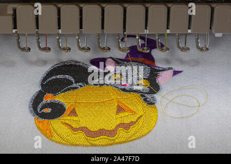 embroidery on a machine in a hoop for celebrating Halloween on fabric with multi-colored threads Stock Photo