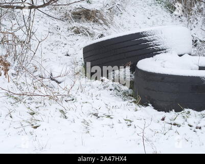 Pair of Snow Covered Used Tires Thrown Away in the Nature Stock Photo