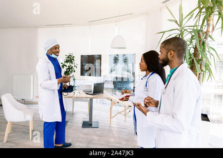 profession, people, surgery, radiology and medicine concept - group of doctors discussing x-rays of patients meeting at medical office Stock Photo