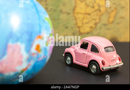 Vintage pink car and globe on map background, travel concept Stock Photo