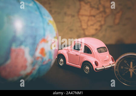 Car and globe with compass on vintage map background, travel symbol around the world Stock Photo