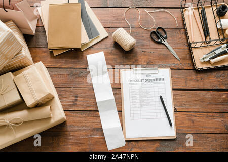 Top view of checklist order surrounded by packed gifts and wrapping items Stock Photo