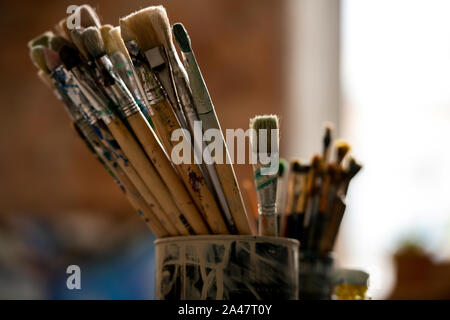 Set of paintbrushes for professional painting in tin can inside modern studio Stock Photo