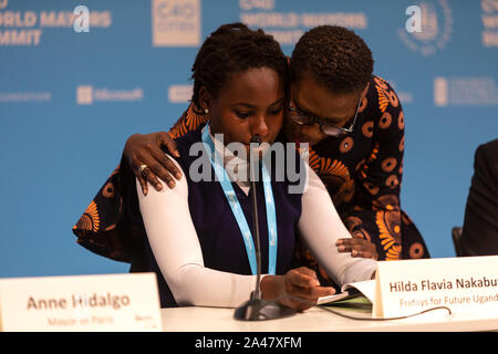 COPENHAGEN, DENMARK – OCTOBER 11, 2019: Hilda Flavia Nakabuye, climate activists within the ‘Fridays for Future’ movement,  Uganda, during the ‘Mayors and Youth Activist’ press conference at the C40 World Mayors Summit. The young activist from Uganda gave a powerful and emotional speech and is here supported by Yvonne Aki-Sawyer, Mayor of Freetown, Seattle.  During the press conference young activist explained what they expect of the grown-up politicians. More than 90 mayors of some of the world’s largest and most influential cities representing some 700 million people meet in Copenhagen from Stock Photo