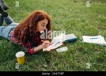 Female student preparing for exams on the grass Stock Photo