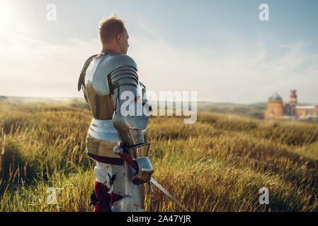 Medieval knight in armor holds sword Stock Photo