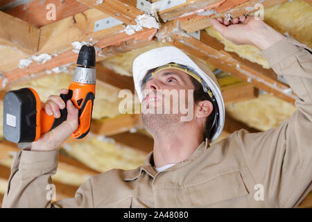 a man drilling the ceiling Stock Photo