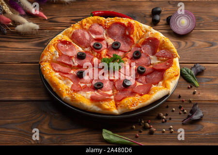 Delicious pizza with olives and sausages on wooden table, top view Stock Photo