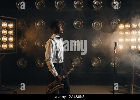 Black jazz musician with saxophone on the stage Stock Photo