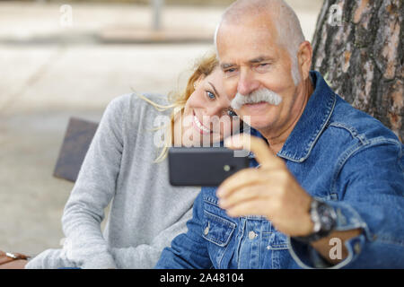girl taking selfie with her grandad Stock Photo
