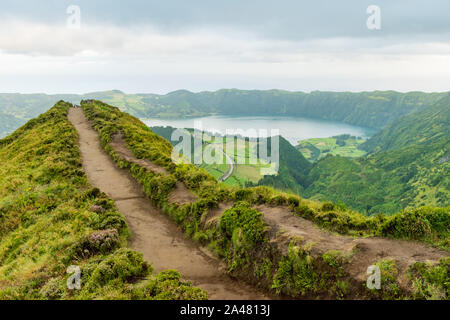 View of a footpath at the Miradouro da Grota do Inferno viewpoint leading towards one of the crater lakes at Sete Cidades on São Miguel in the Azores. Stock Photo