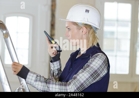 beautiful female builder using walkie talkie Stock Photo