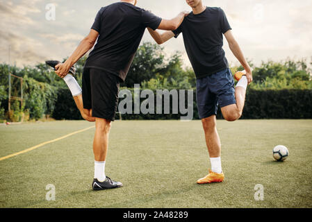 Two soccer players doing stretching exercise Stock Photo