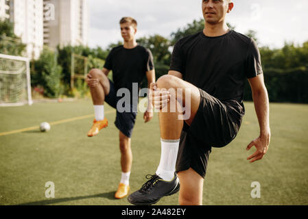 Male soccer players doing stretching exercise Stock Photo
