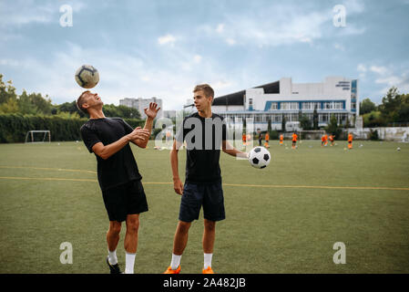 Soccer players training with balls on the field Stock Photo