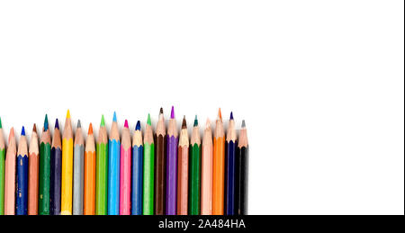 Old colored pencils. Some old colored pencils lined up on a white table. Stock Photo