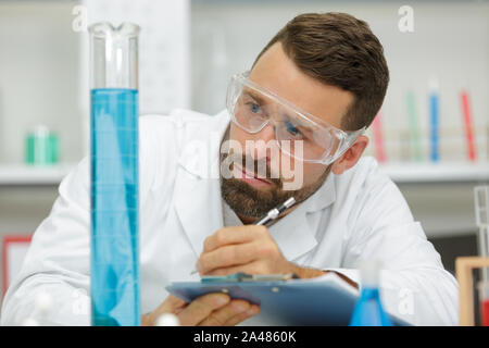 scientist checking a solution in conical flask Stock Photo