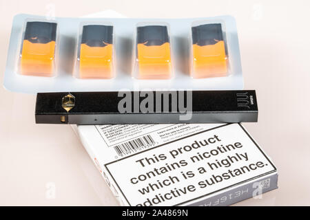 juul pod warning label MORGANTOWN, WV - 12 October 2109: Warning sign for Juul e-cigarette or  nicotine vapor dispenser box on and flavored JUULpods on light background  Stock Photo main image 1