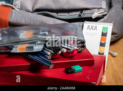 MORGANTOWN, WV - 12 October 2019: Juul e-cigarette or nicotine vapor stick and JUULpods in pencil case on school backpack Stock Photo